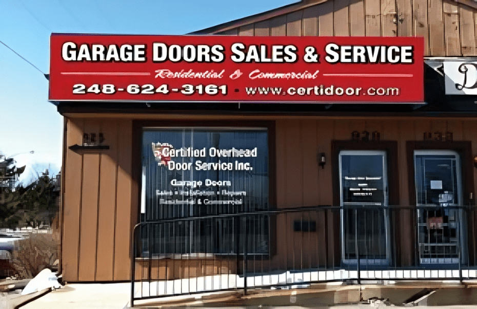 A garage door sales and service sign on the side of a building.